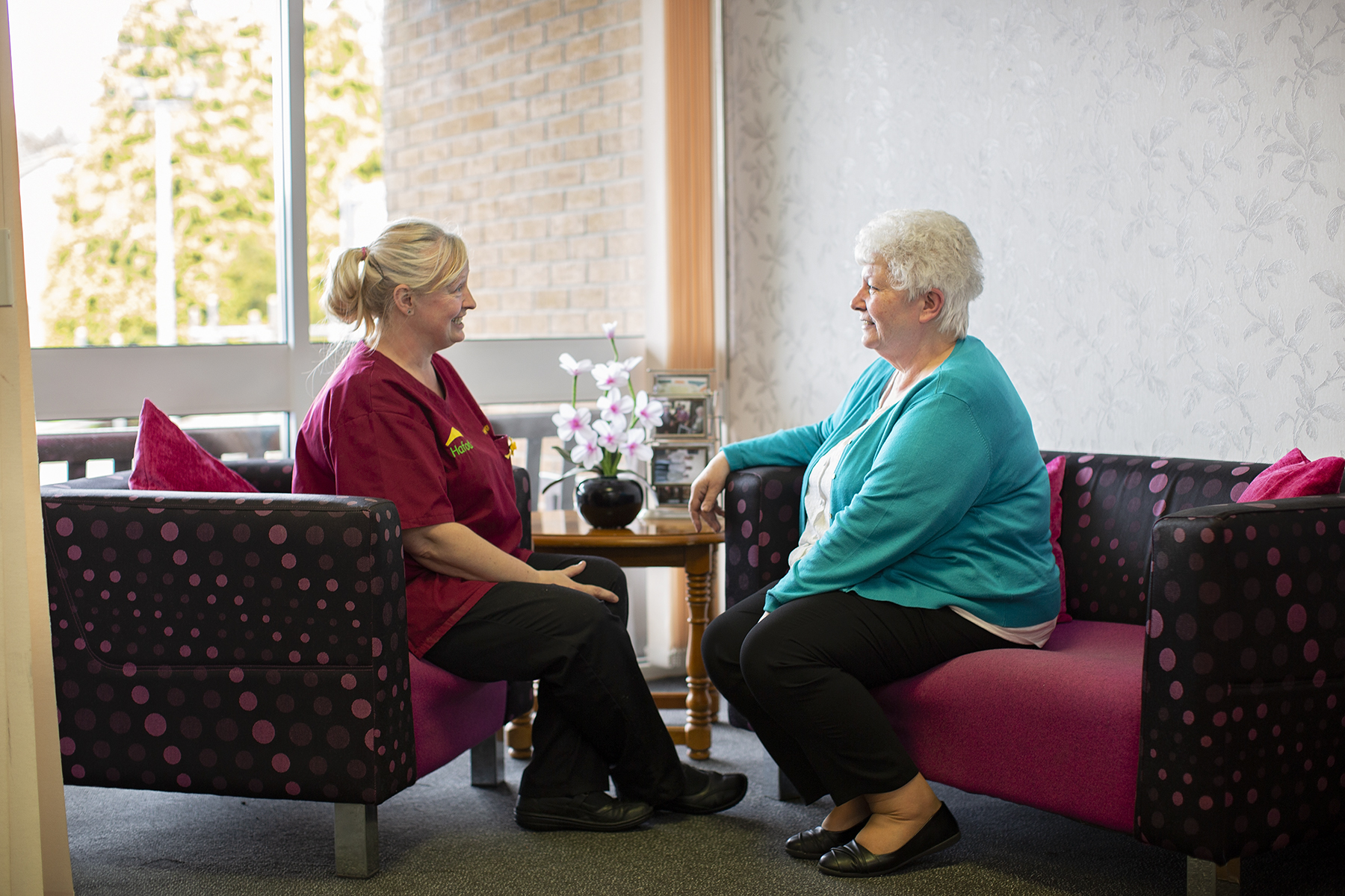 Colleagues at Arthur Jenkins care home chatting while sitting on chairs
