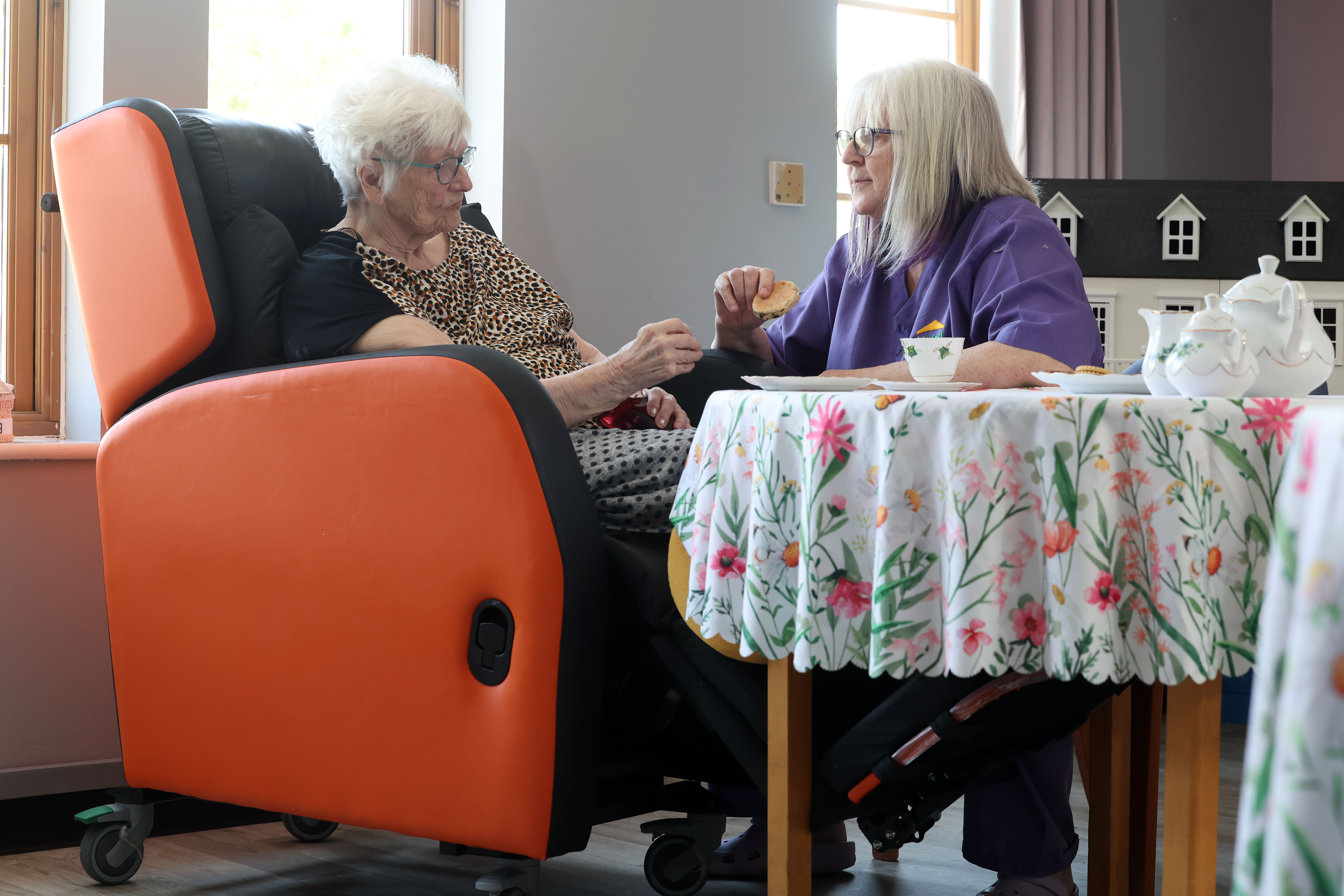Resident in a chair talking to a carer