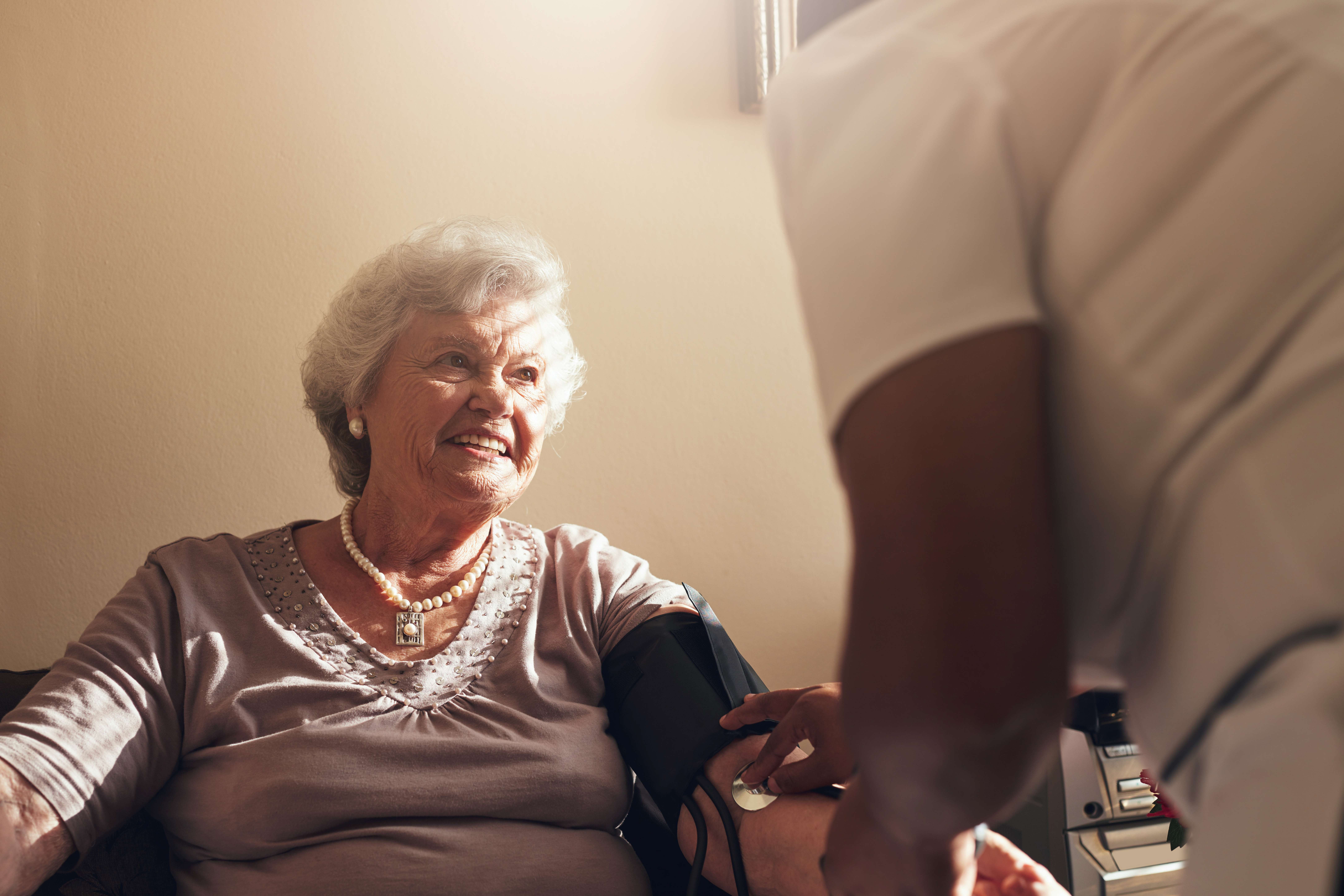 Carer taking a woman&#039;s blood pressure