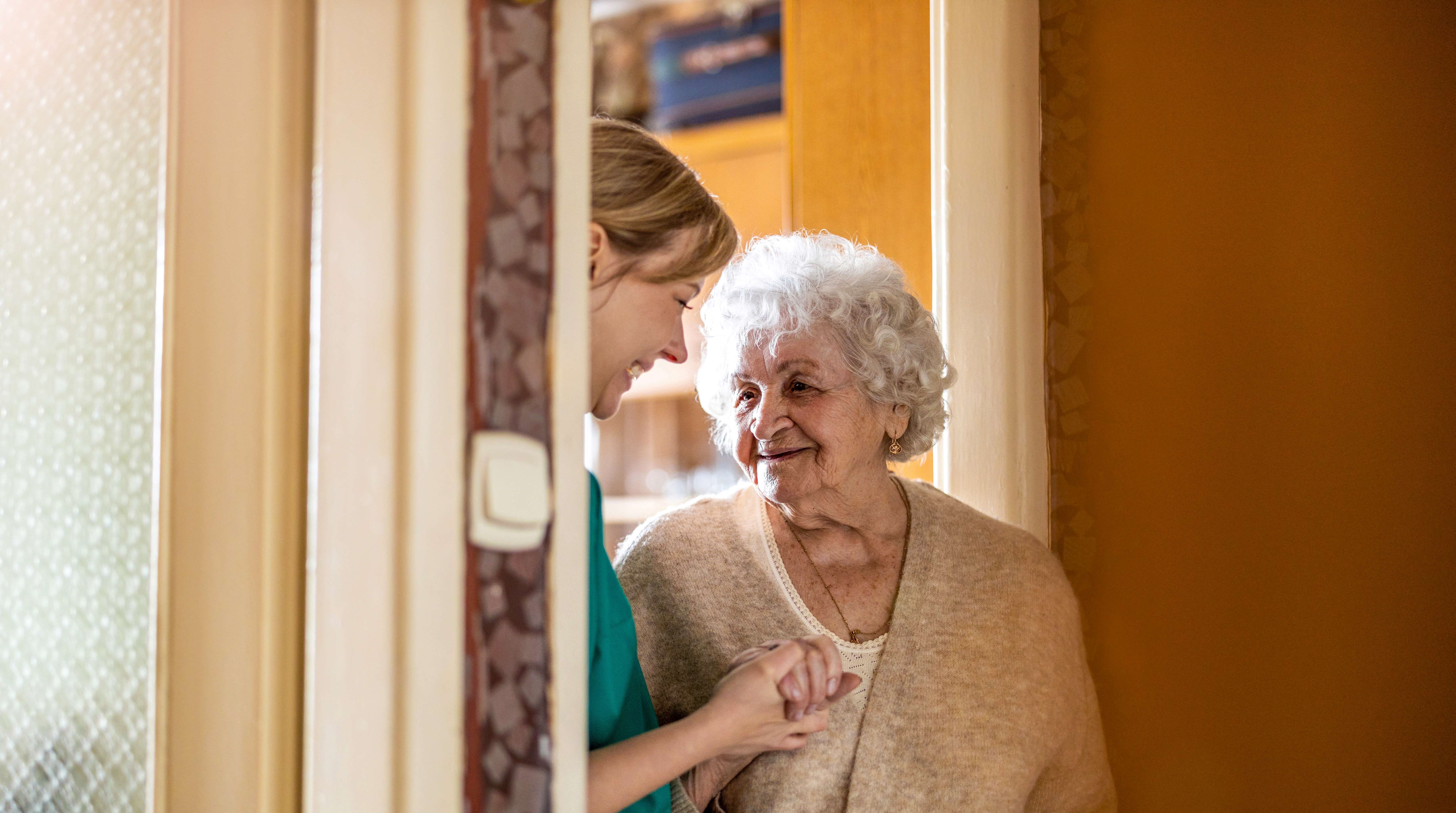 Lady standing in a doorway with her carer