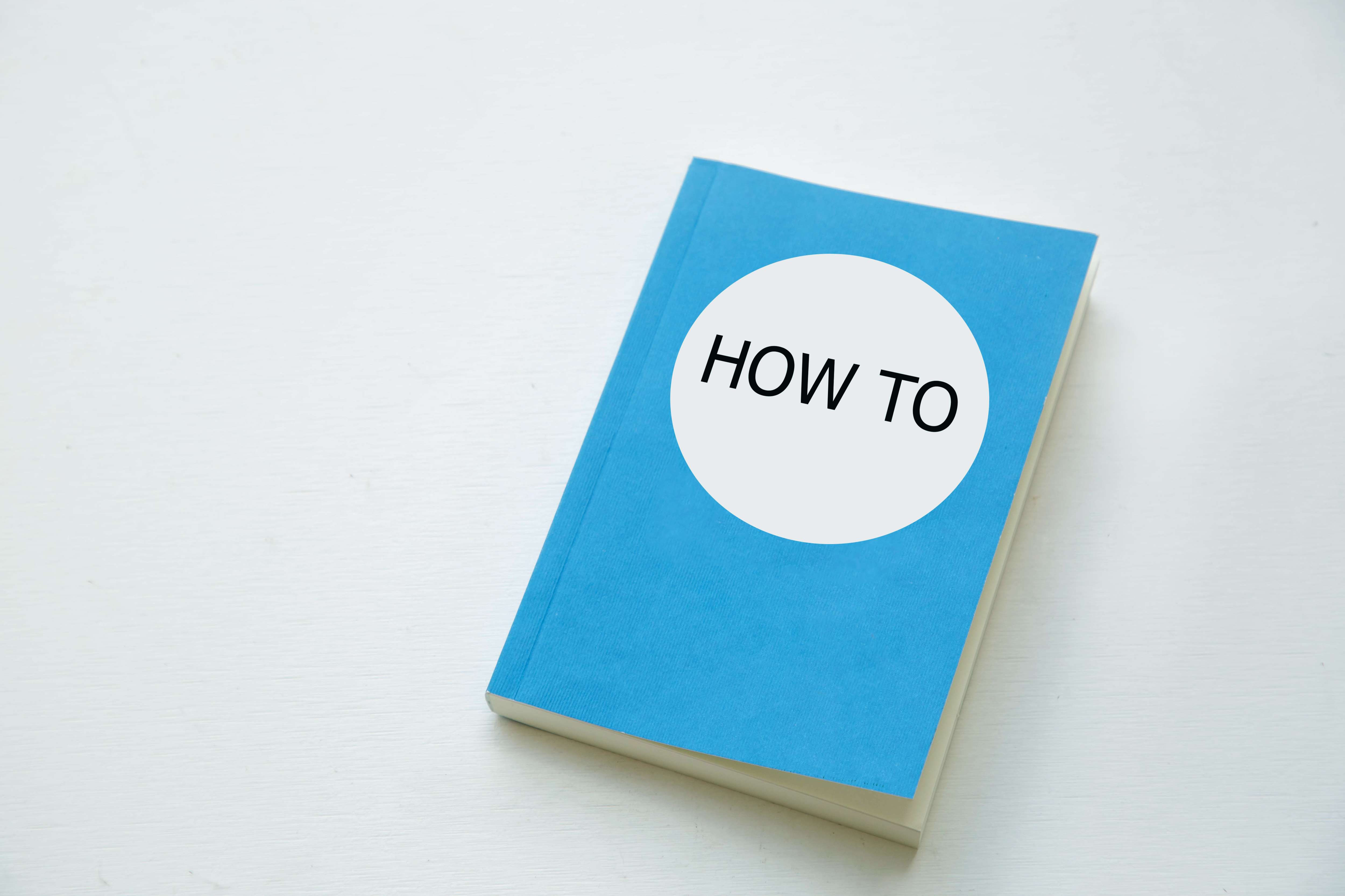 A book with the title &#039;How to&#039; lying on a table