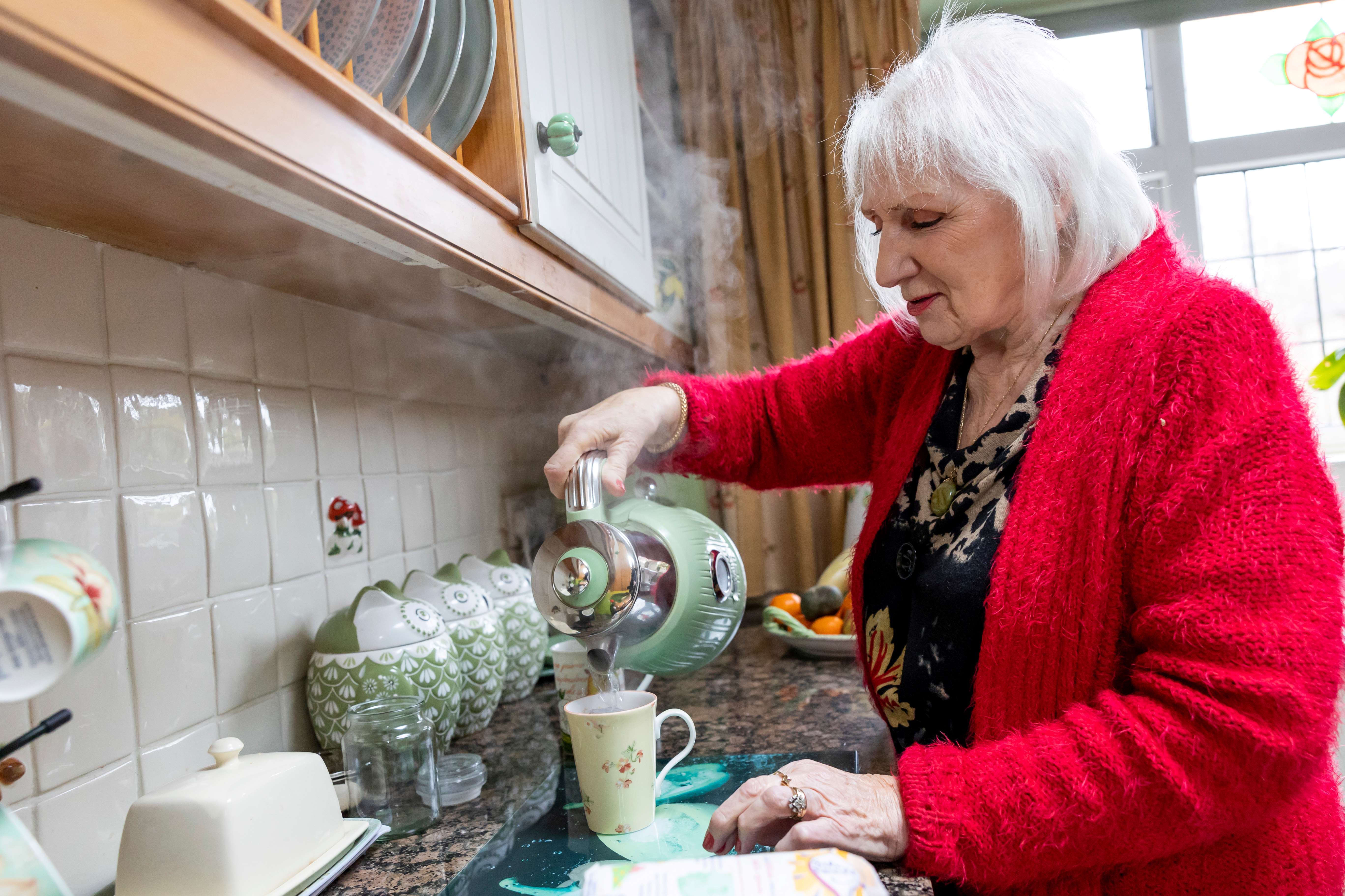 Lady pouring tea in her kitchen