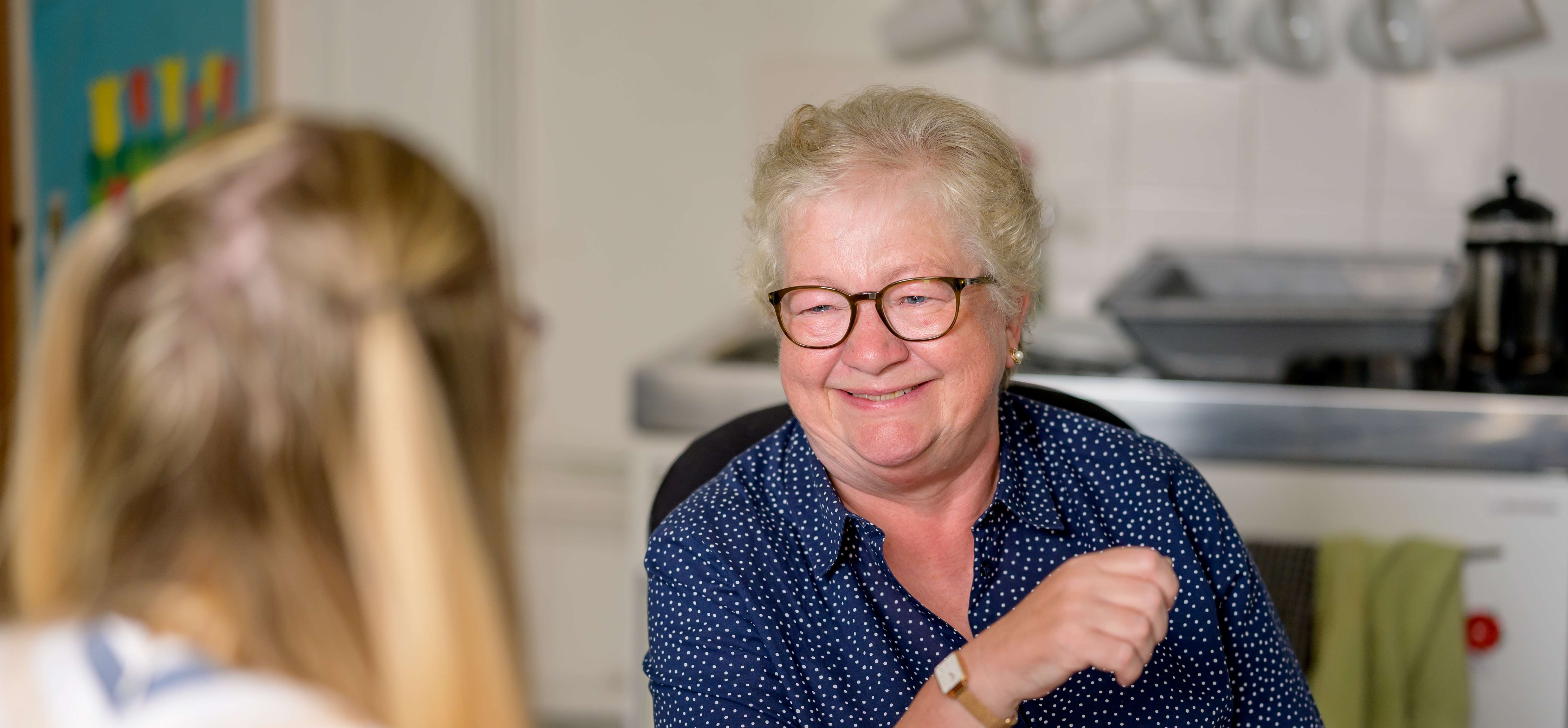 Lady smiling and chatting with someone