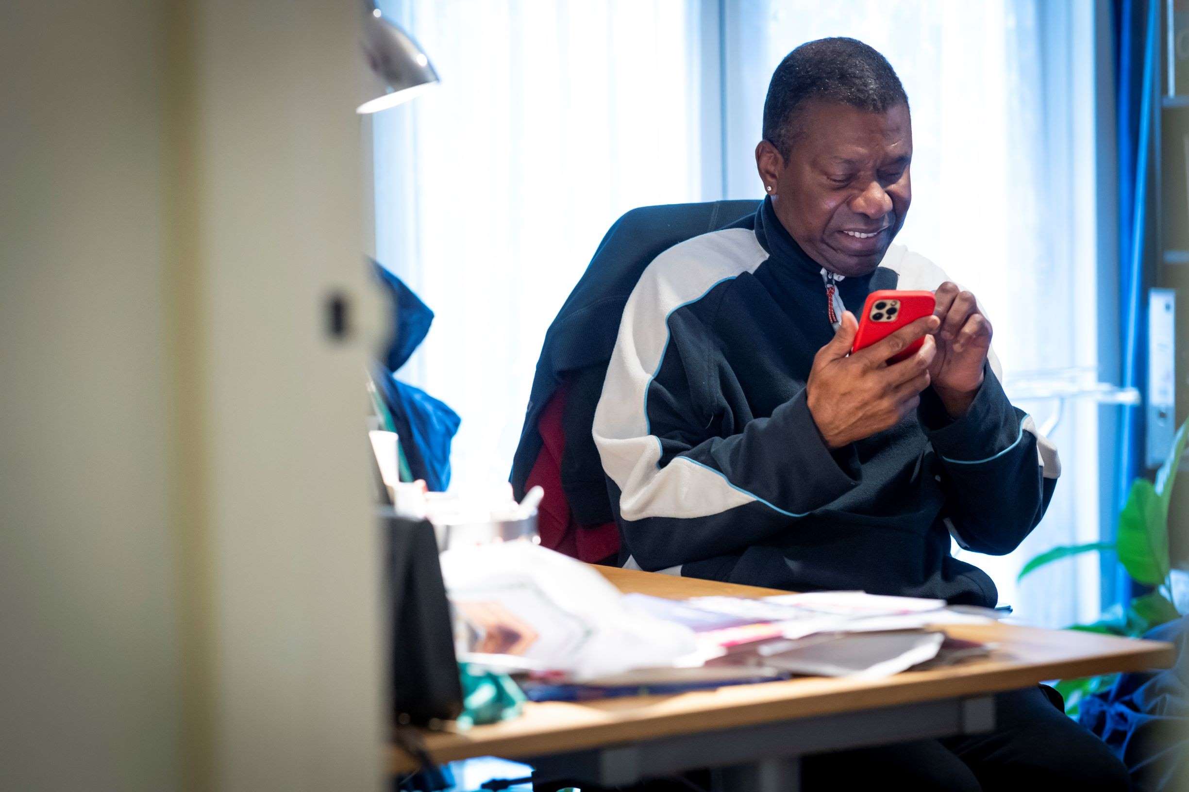 Man using his phone sitting at his desk