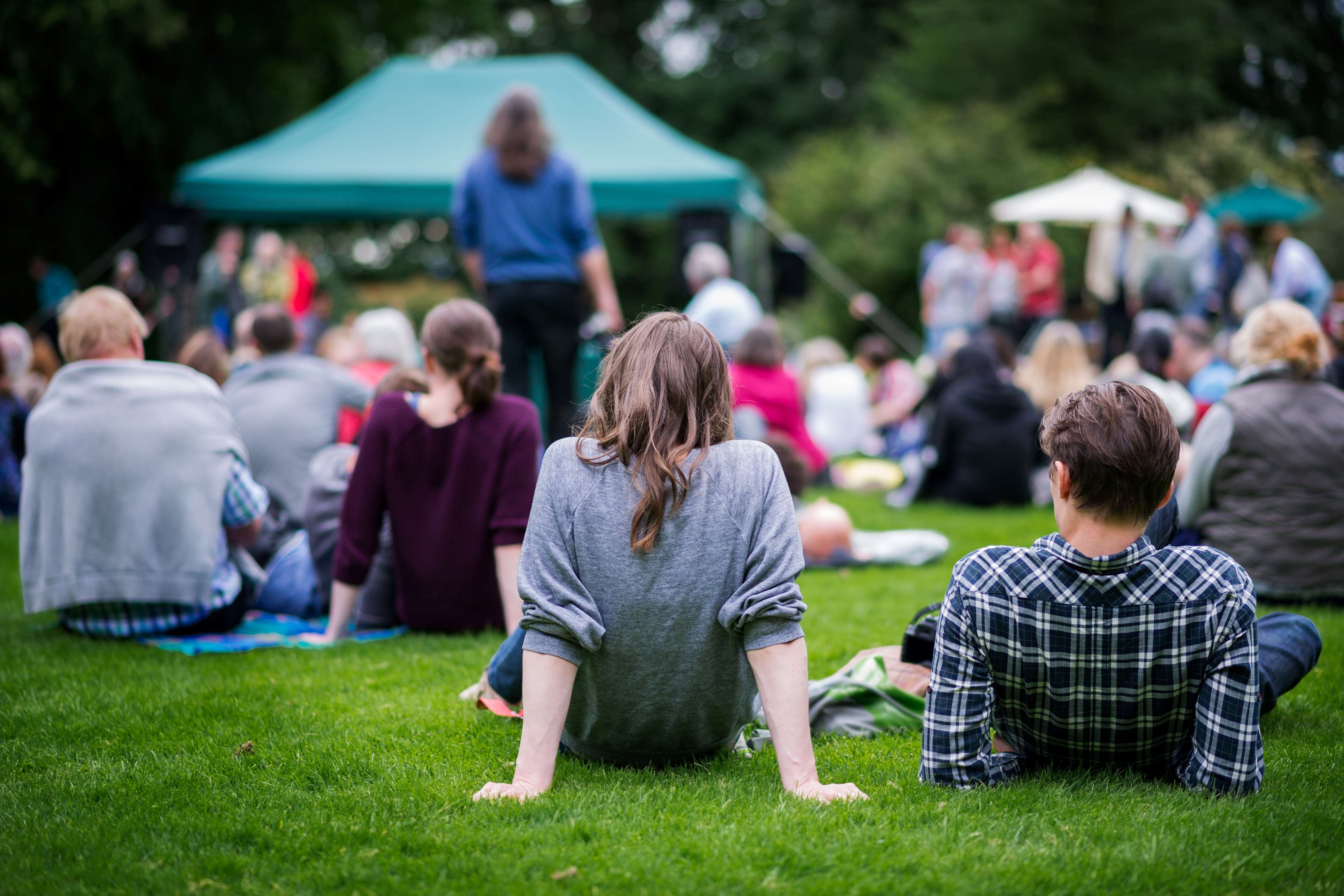 People sitting on the grass at a community event