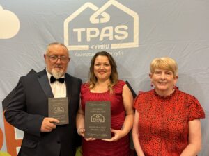 Three people in smart dress holding TPAS awards
