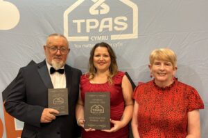 Three people in smart dress holding TPAS awards