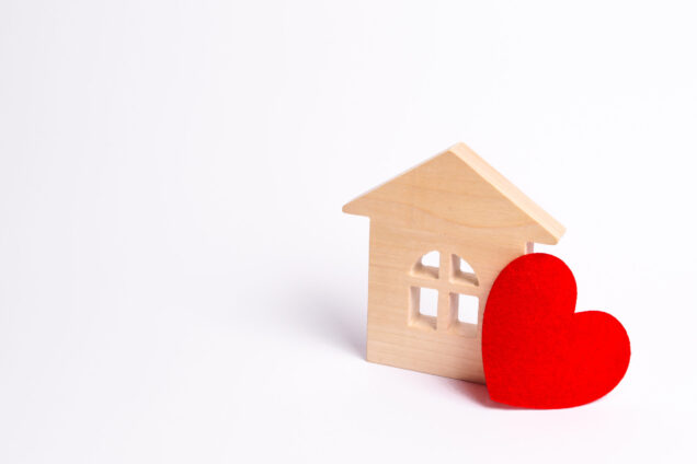 Wooden house with a red heart on a white background