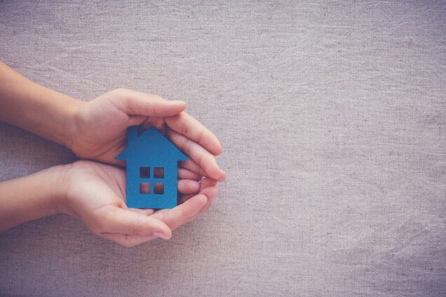 hands holding paper house