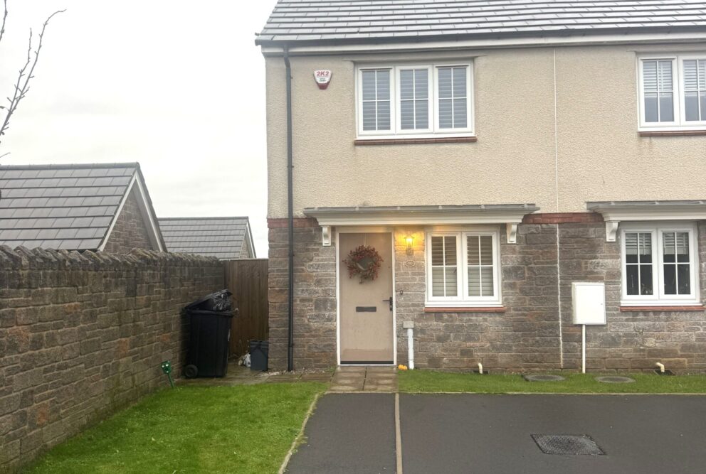 External image of the front of a two-bedroom end-of-terrace modern home. The bottom half is natural stone and the top half is cream render.