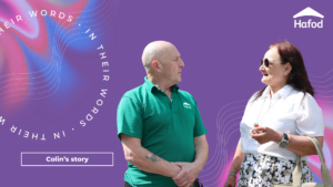 A purple backgorund with Colin, a man wearing a green polo top speaking to a lady wearing a white tshirt and floral skirt.