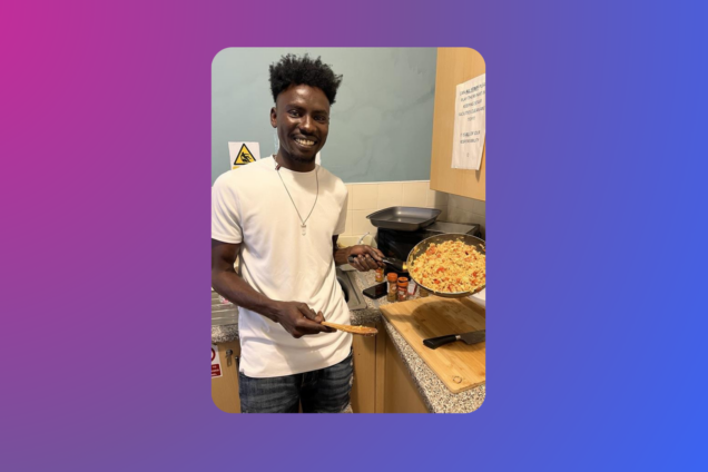 Moner in a kitchen holding a pan with Tawa in it