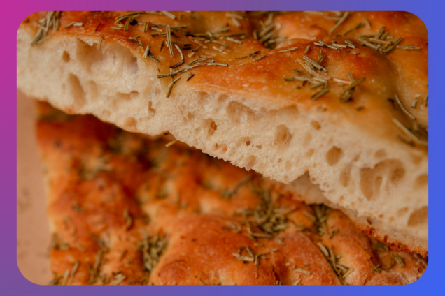 a focaccia bread cut into two on a purple and blue background