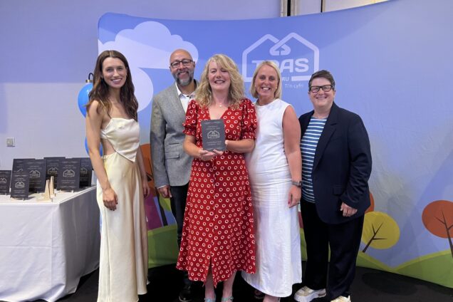 Our Decarbonisation and Assets team receiving their TPAS Cymru Award on stage.