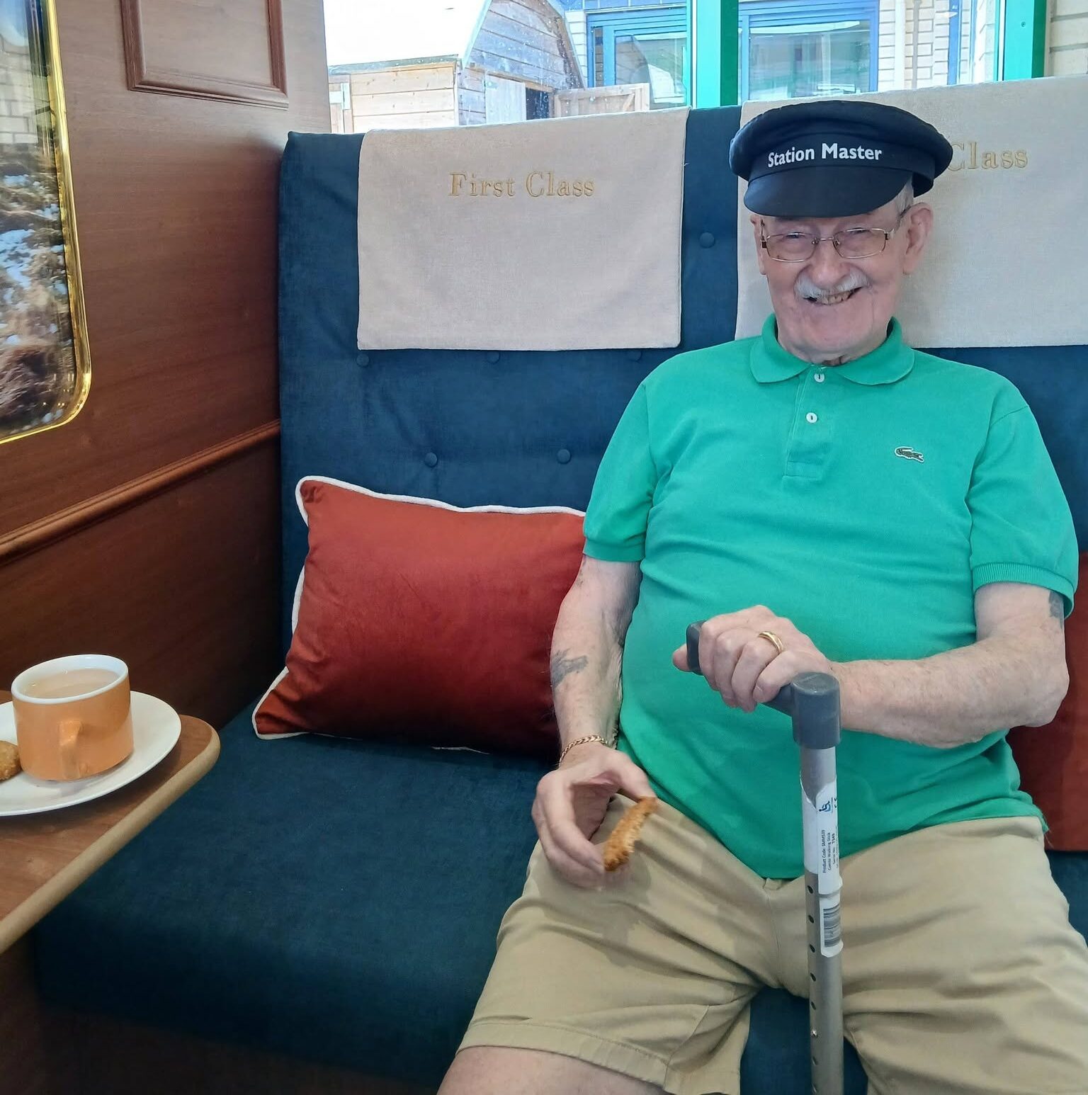 Bernard wearing a train divers hat, smiling aboard the Jolly Journey train carriage