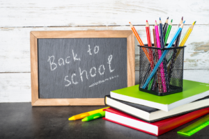 A whiteboard showing the words back to school with some books and pencils